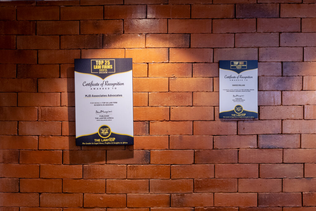 2 prominent awards that MJD has won hanged on a brick like wall